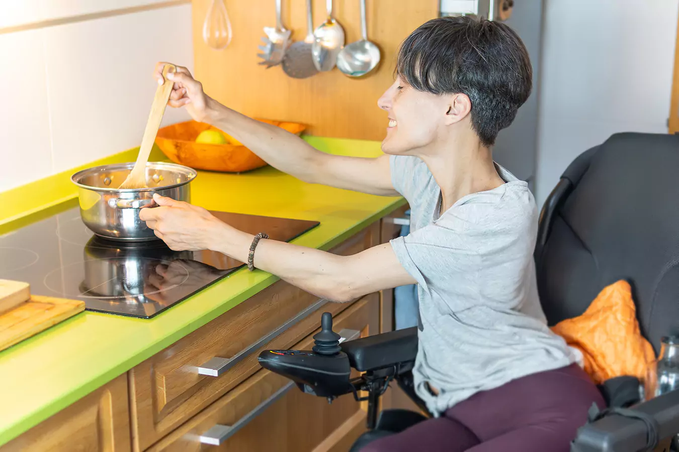 A disabled man sitting in his wheelchair while cooking