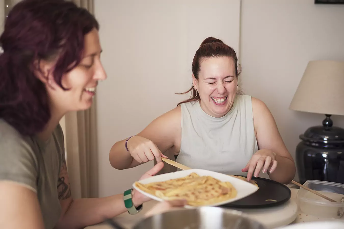 Two women smiling while cooking